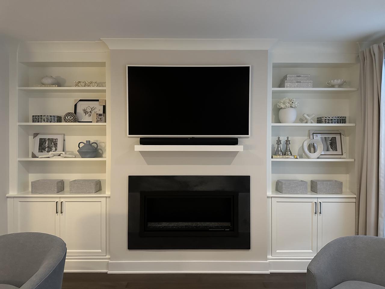 Built-in shelving flanking a fireplace and TV