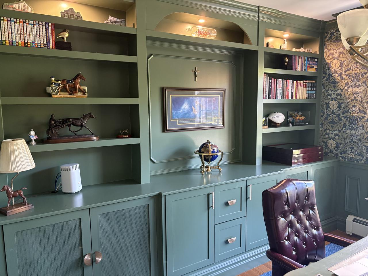 Sage green built-in office cabinetry and shelving