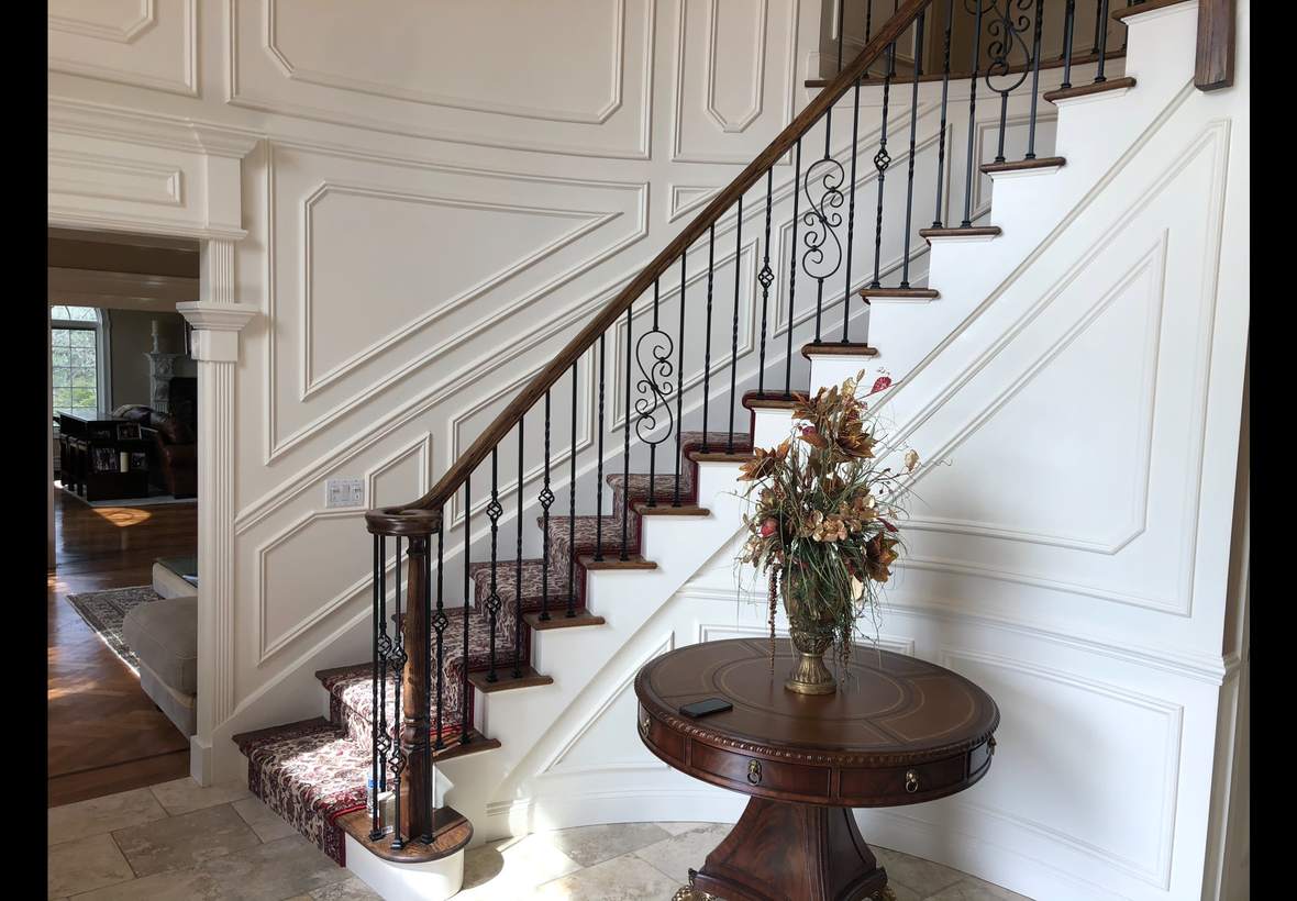 Staircase wall with raised panel wainscoting after