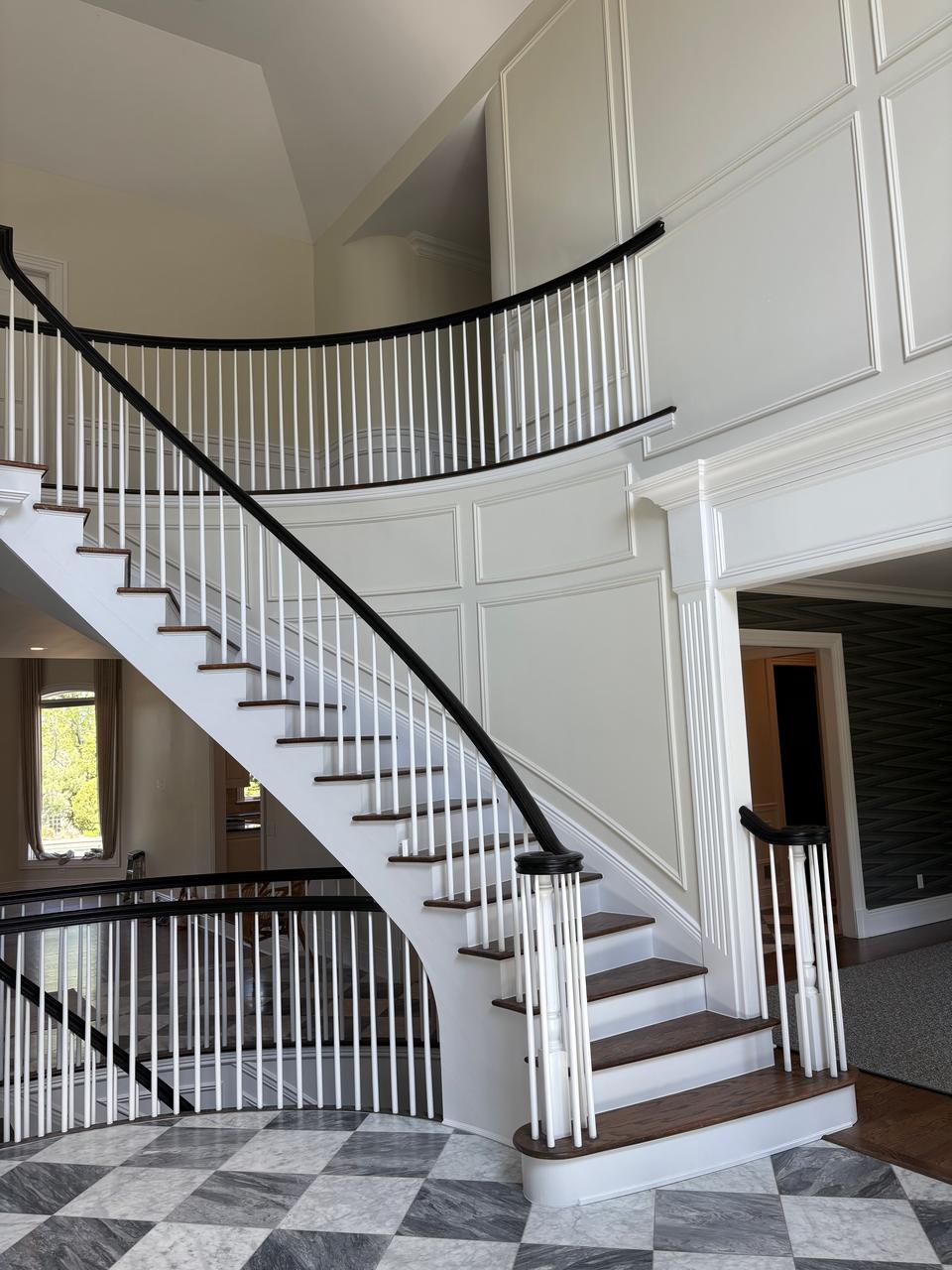 Curved staircase with black iron railing