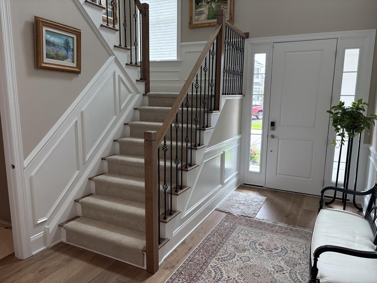 Foyer staircase with wainscoting and front door