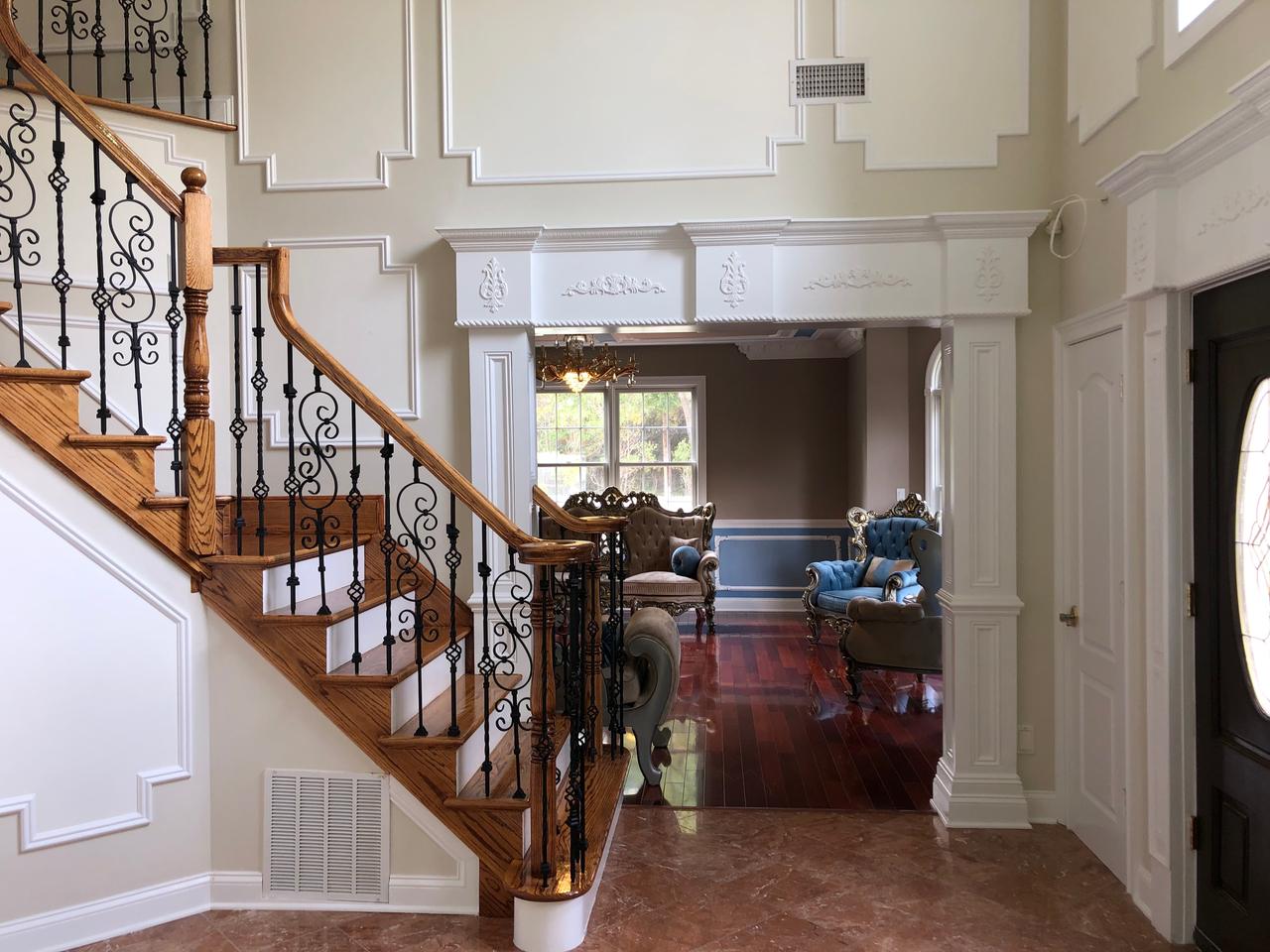Staircase with wood railing and entry hall