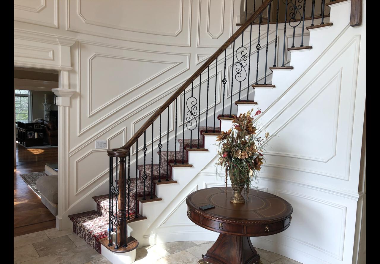Staircase with wrought iron railing and marble floor