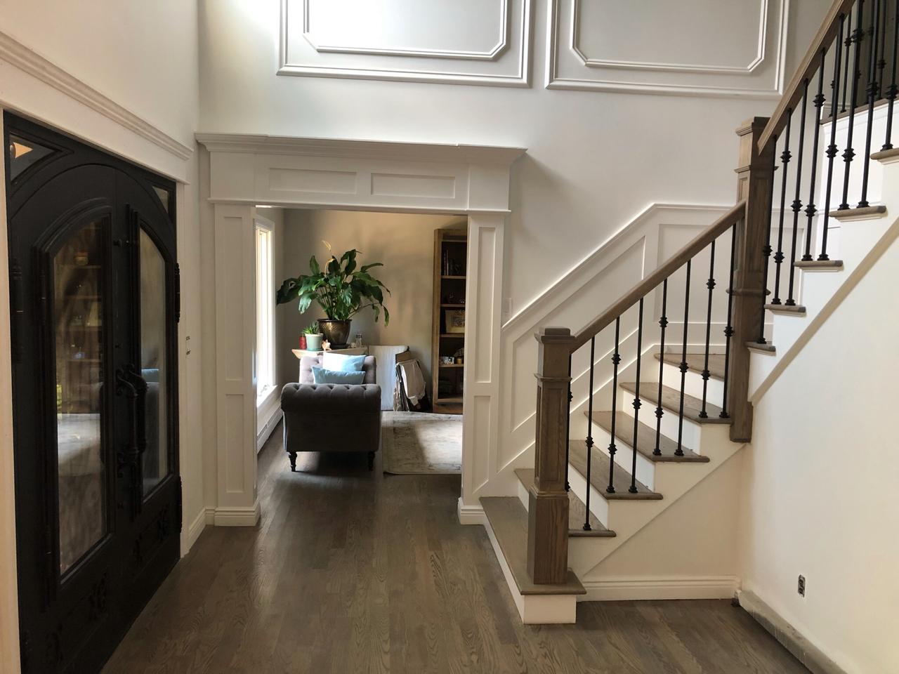 Staircase with wrought iron railing near an archway