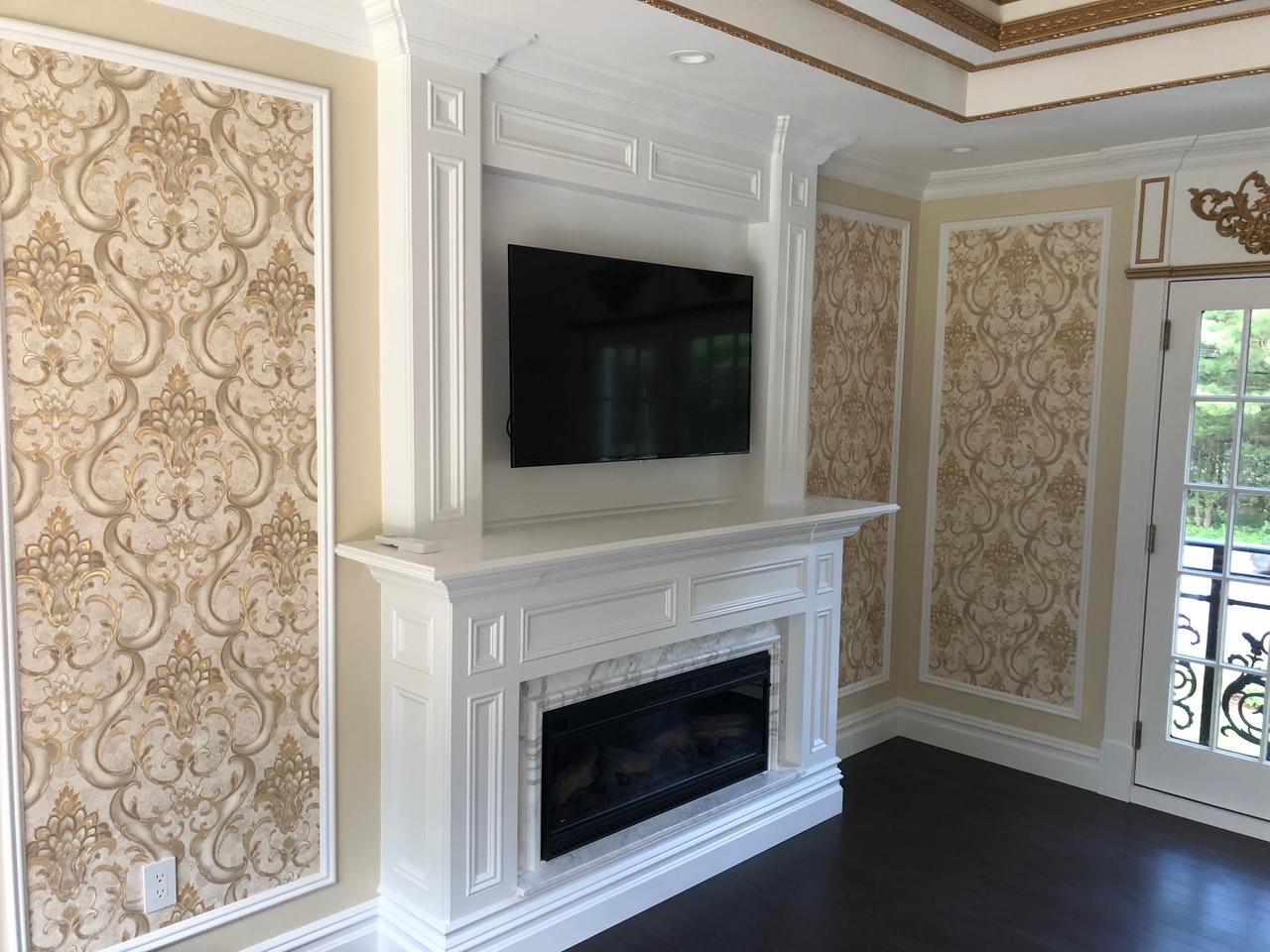 Gold-trimmed wainscoting around a marble fireplace