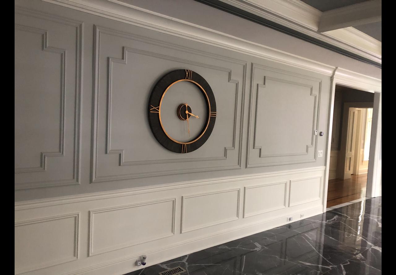 Raised panel wainscoting wall with round mirror